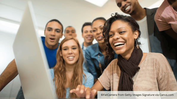 students at a computer together smiling