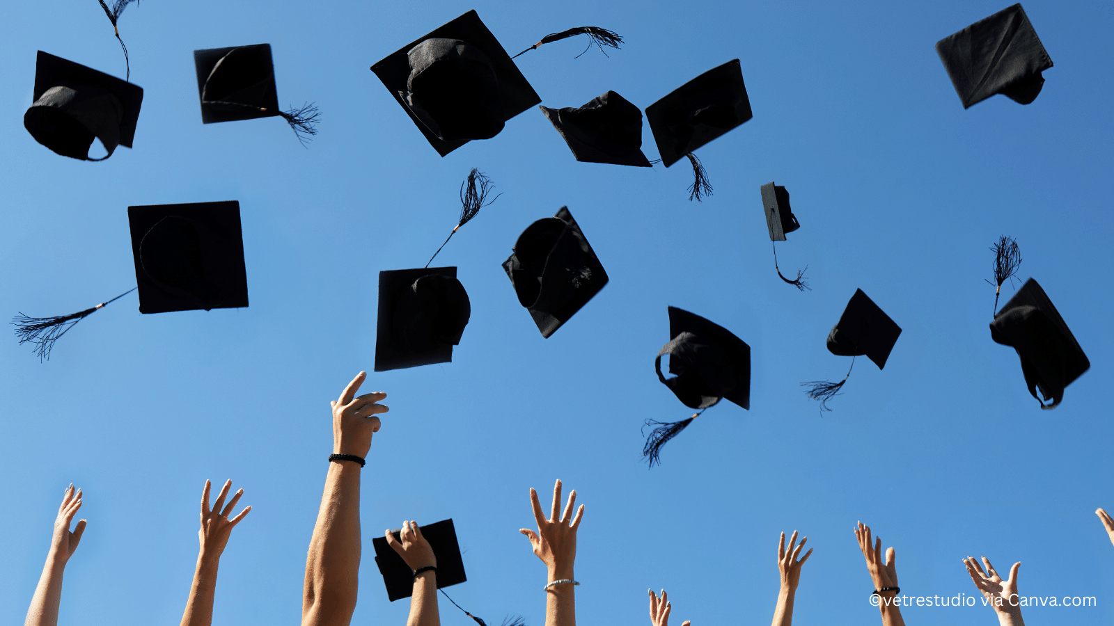 alumni throwing hats in the air