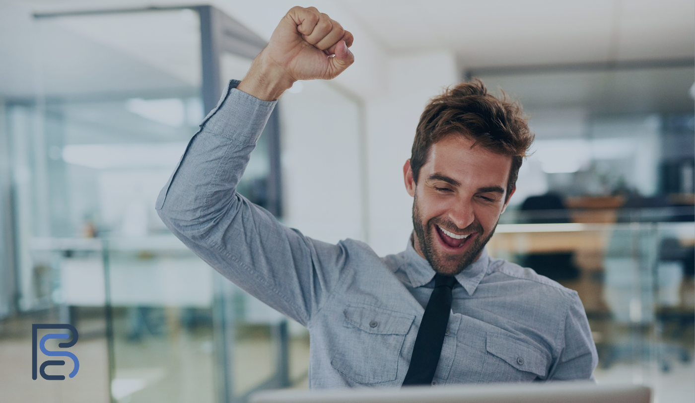 man celebrating getting a yes - fist in the air, smile on his face