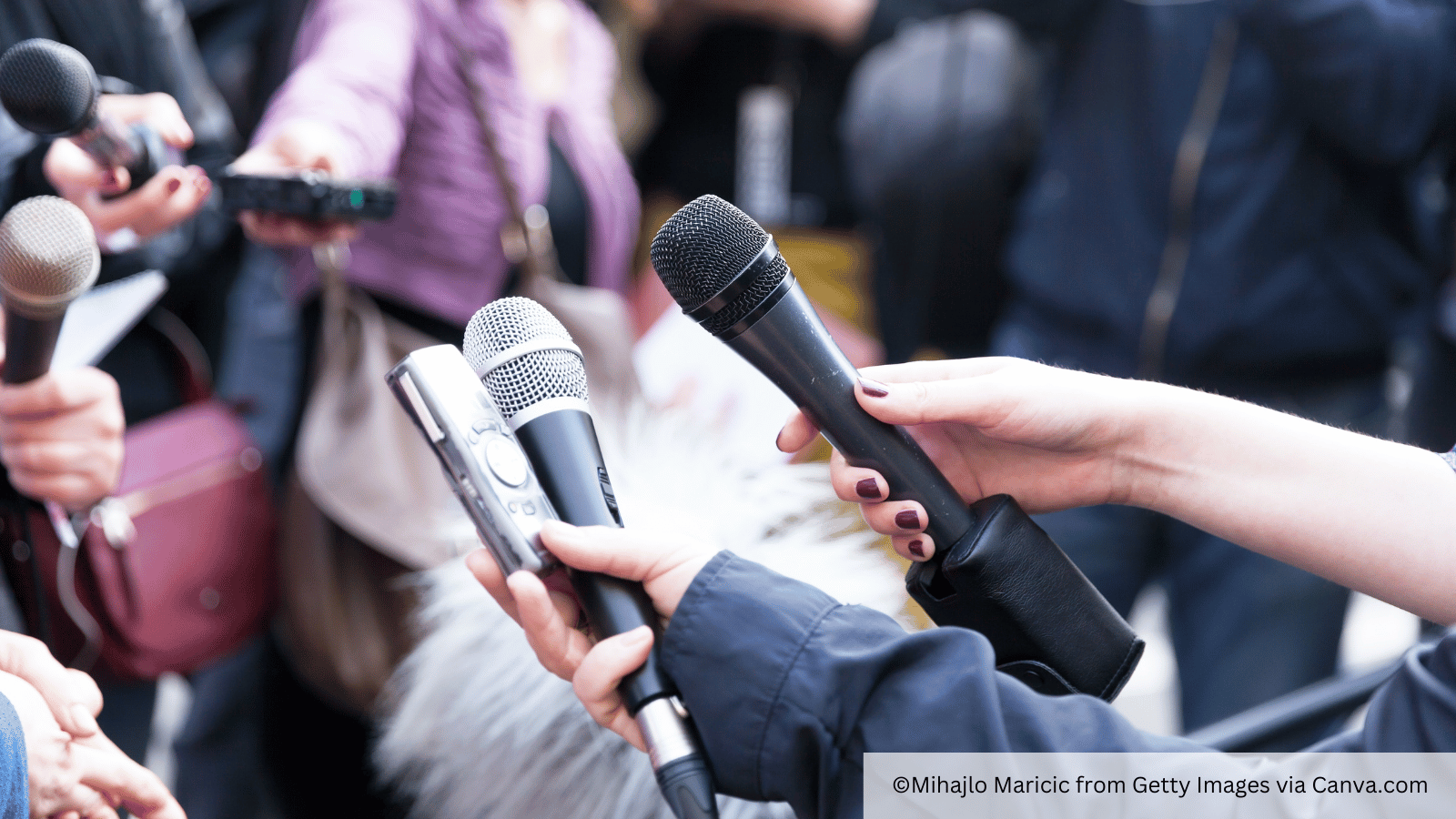 journalists with microphones looking for comment
